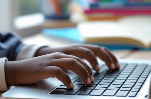 black school-aged child's hands typing on a laptop
