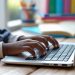 black school-aged child's hands typing on a laptop