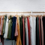 Clothing rack displaying colorful women's trousers and shorts in neutral and classic colors for building a timeless wardrobe.