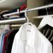 Picture of inside of a closet with a white collared shirt being prominently featured.
