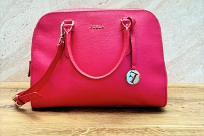 Hot pink Furla structured leather satchel handbag with gold hardware, double handles, detachable shoulder strap, and signature Furla charm.